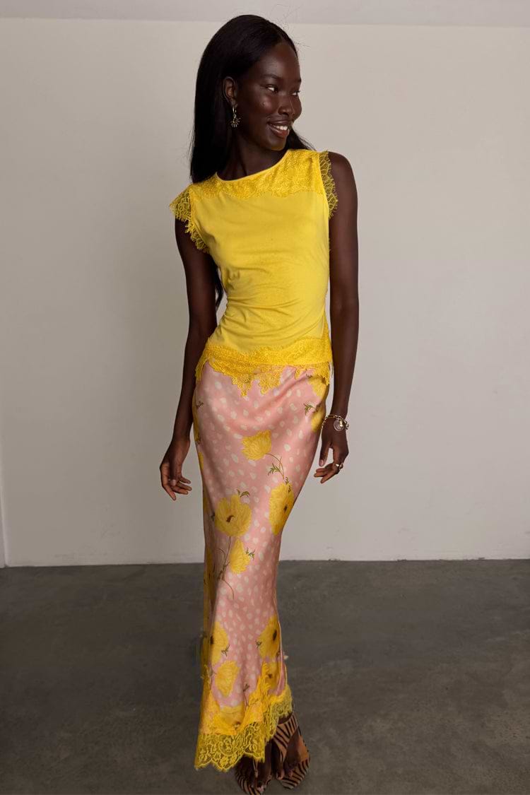 Pink Fawn Poppy Midi Maeva Skirt with yellow lace trim and deer motifs, designed in London and styled with a yellow top.