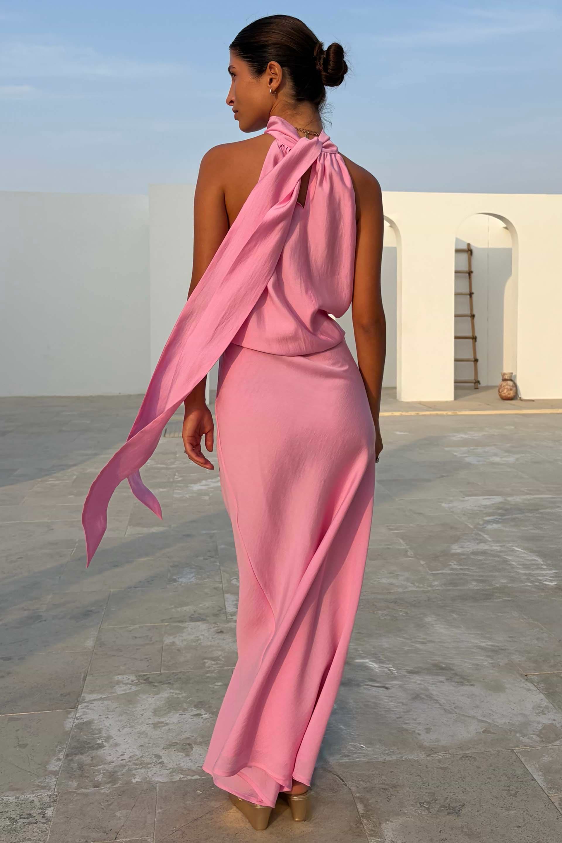 Pink Billie Top featuring a draped halterneck and long multi-wear tie detailing, styled with a matching pink skirt.