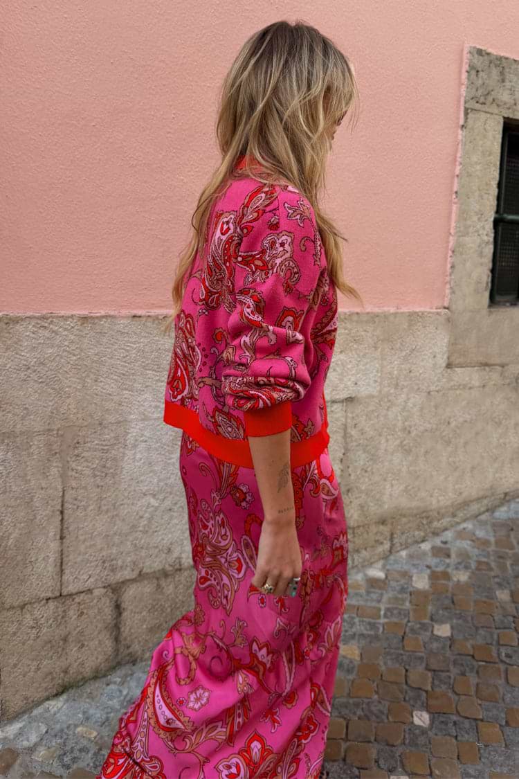 Pink Paisley Oslo Cardigan with an intricate red print and ribbed cuffs, worn as a dopamine dressing co-ord.
