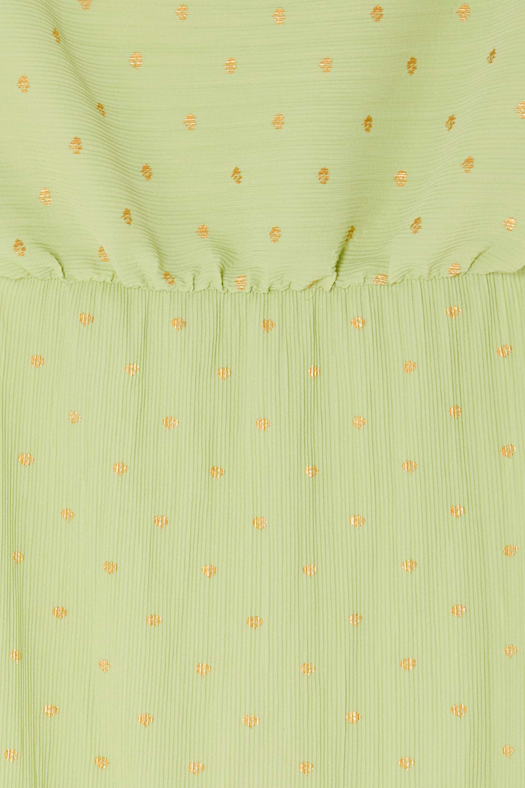 Pistachio green plisse fabric detail of the Tilly Dress featuring subtle gold flecks and an elasticated waistband.