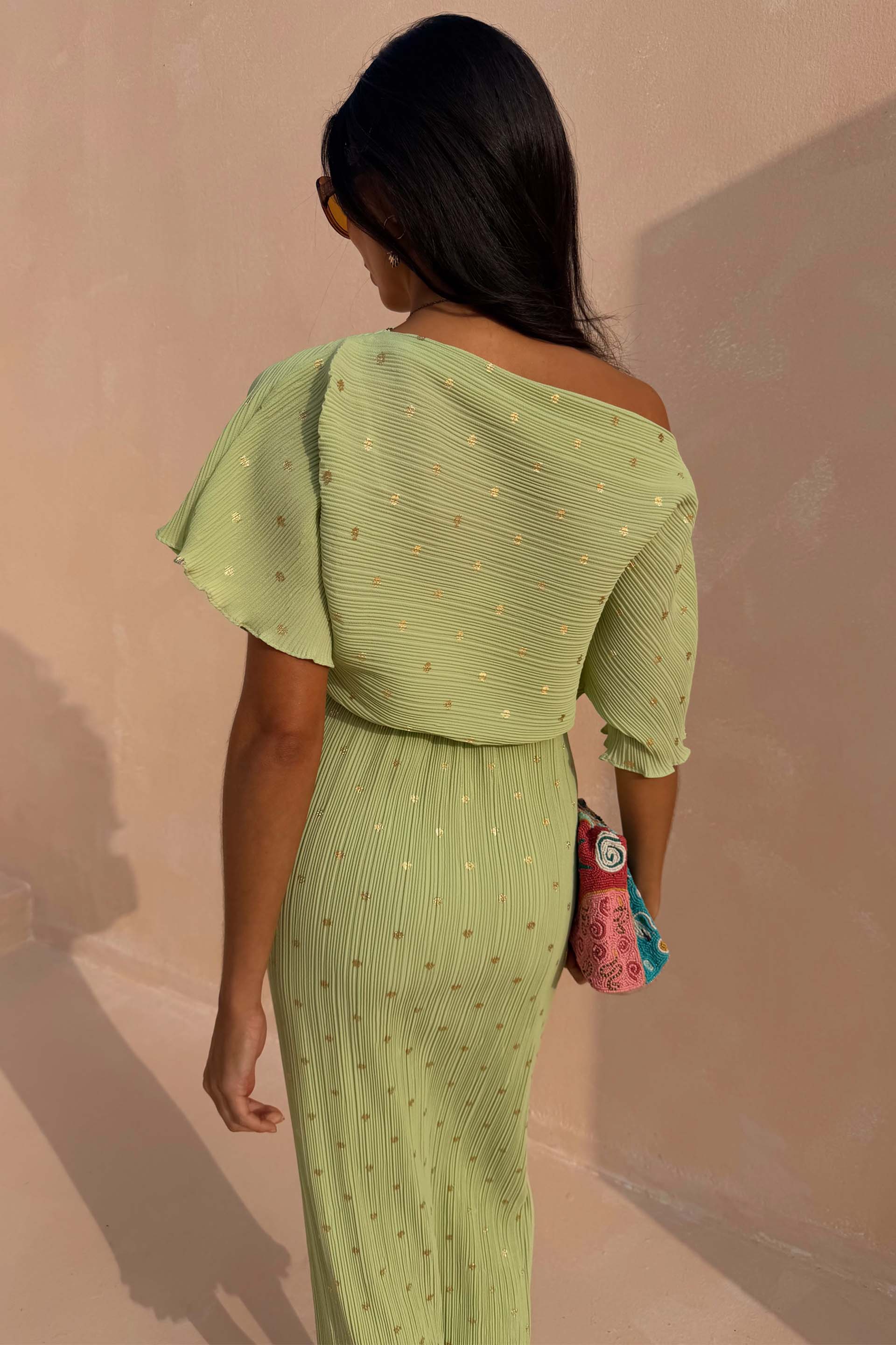 Pistachio Tilly Dress in green plisse with gold flecks, featuring an off-the-shoulder neckline and lettuce hems.