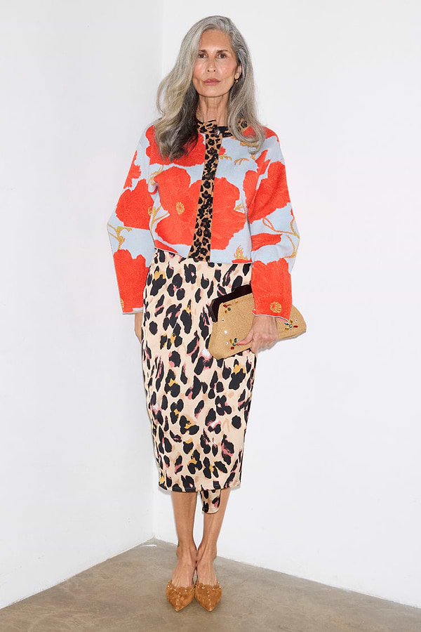 Blue Poppy Cardigan with a red poppy print and leopard trim, styled with a leopard midi skirt on a silver-haired model.