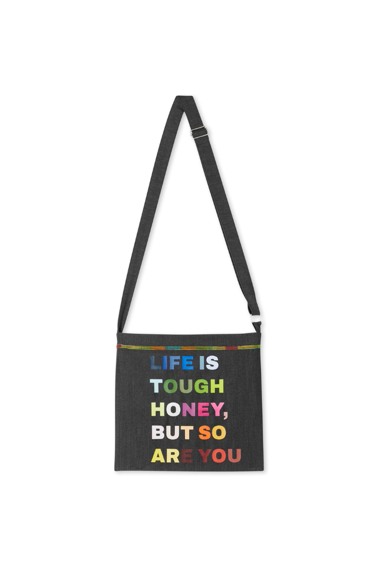 Charcoal Life is Tough Honey drainage bag with multi-coloured text and an adjustable shoulder strap.
