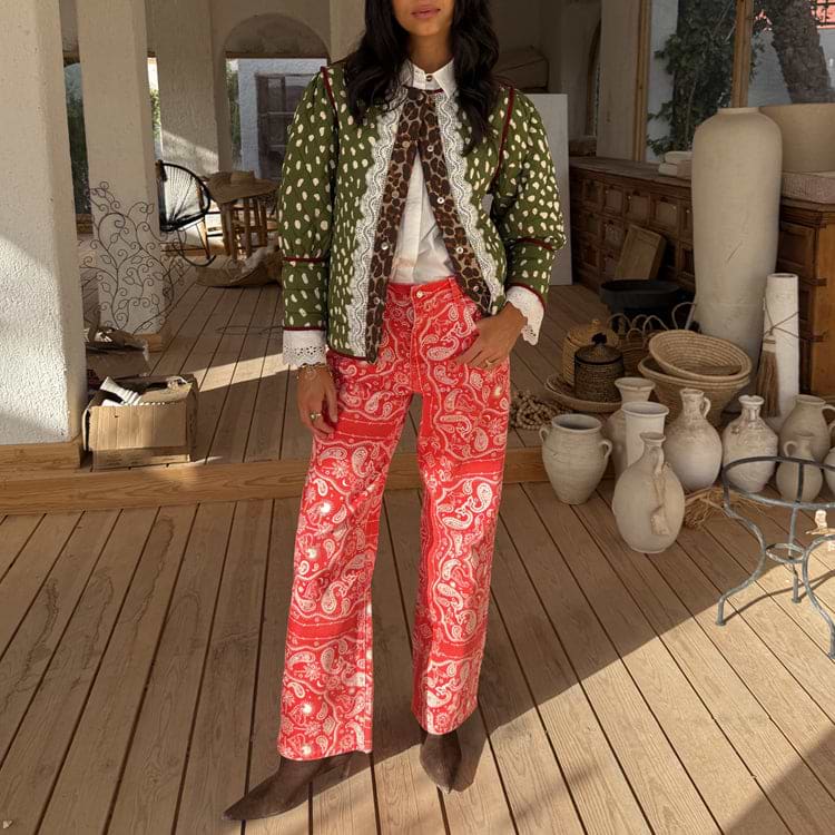 Red Bandana Jeans in a straight leg fit with a white paisley print, paired with a green quilted jacket.
