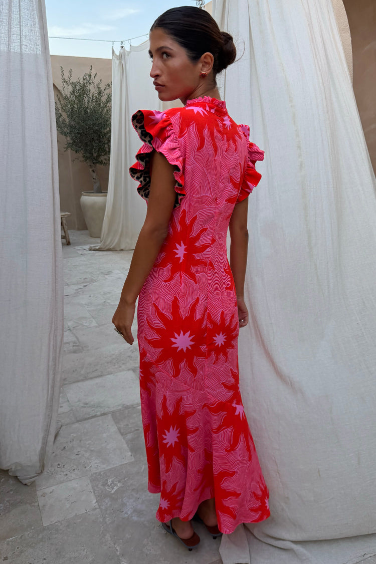 Pink Soleil Remi Dress with red sun motifs, pleated frill sleeves with leopard lining and an asymmetrical skirt.