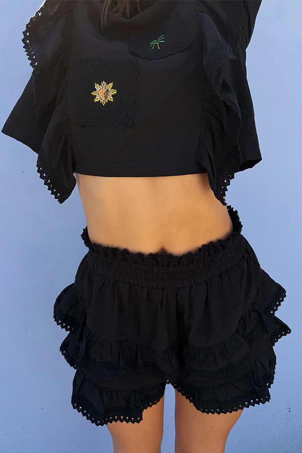 Black Ruffle Shorts with tiered lace trim and an elasticated waistband, styled as a co-ord with a matching embroidered top.