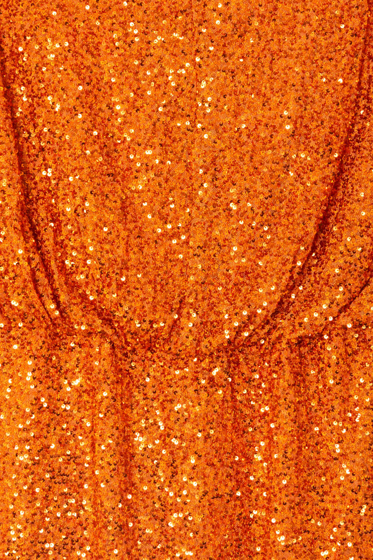 Orange Sequin Tilly Dress detail highlighting the shimmering burnt orange sequins and elasticated waistband.