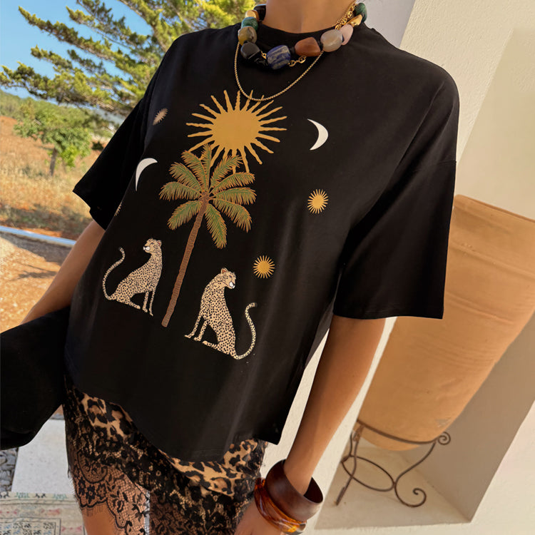 Black Running Wilder T-shirt in a boxy cotton fit with an iconic sun and leopard print, styled with a lace skirt.