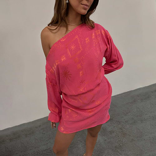 Pink Safari Mini Tilly Dress in pink jacquard with orange sun and palm prints, styled off-the-shoulder.