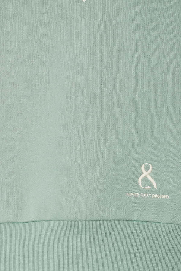 Sage green Sage Sundazed Accessible Sweatshirt detail featuring an embroidered white logo and ribbed hem.