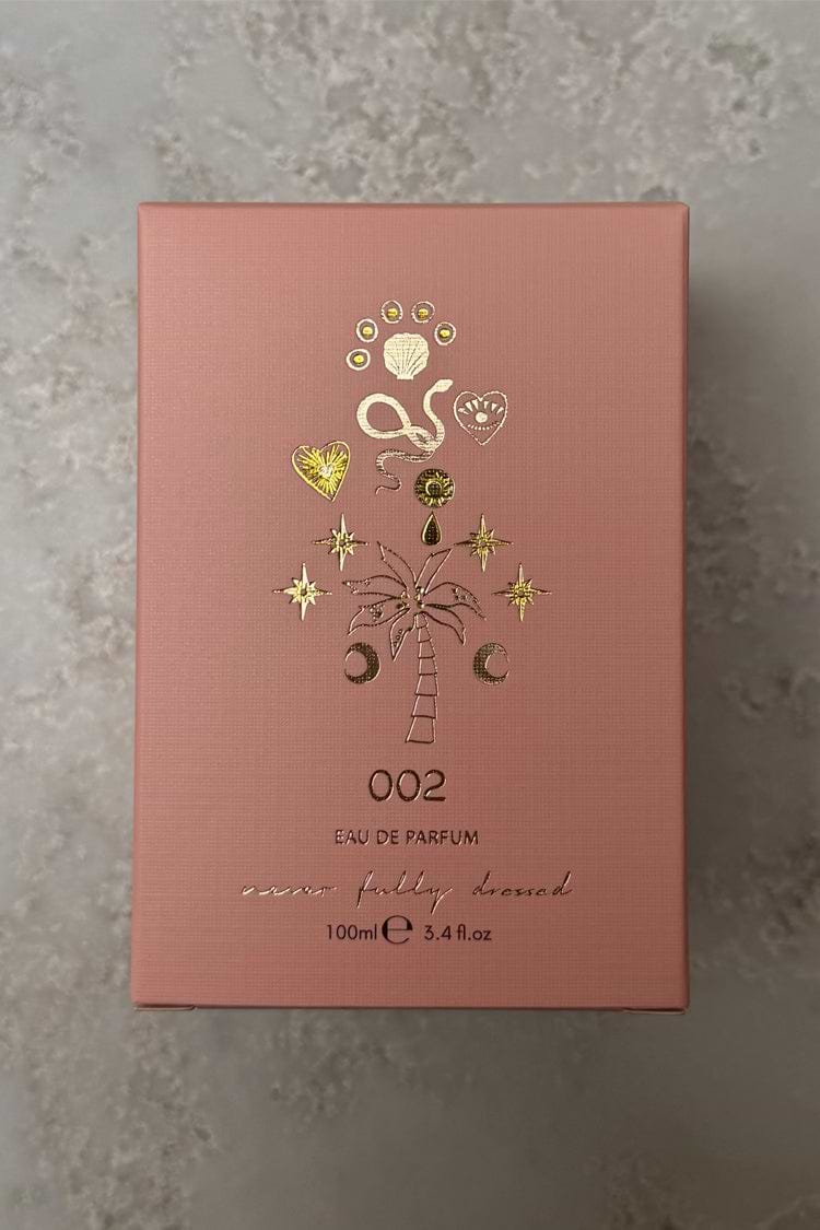 NFD Eau De Parfum 002 in a pink textured box with gold foil palm tree and celestial illustrations.