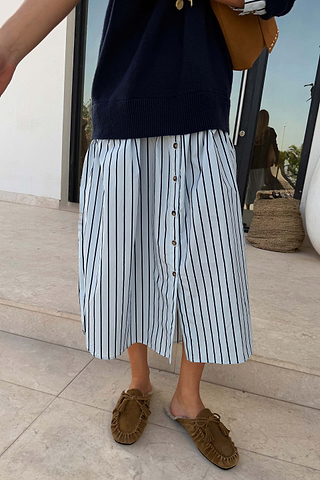 Navy knit jumper dress with a blue striped cotton midaxi skirt and buttons, styled with brown loafers for London looks.