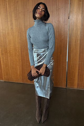 Iconic Silver Vegan Leather Jaspre Skirt styled with a grey roll neck and brown suede boots.