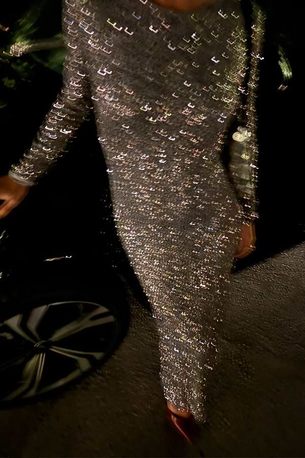 Gunmetal Sequin Soho Dress with long sleeves and a shimmering finish in a motion-blurred party setting.