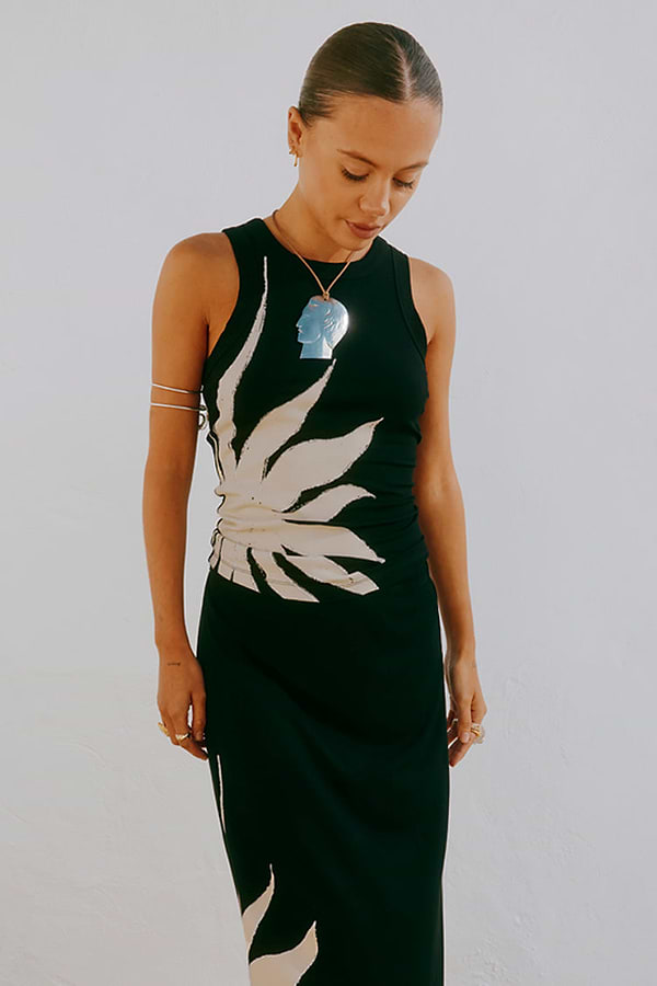 Black Sol Tank Top featuring a hand-painted sun print, styled with a matching skirt and silver jewellery.