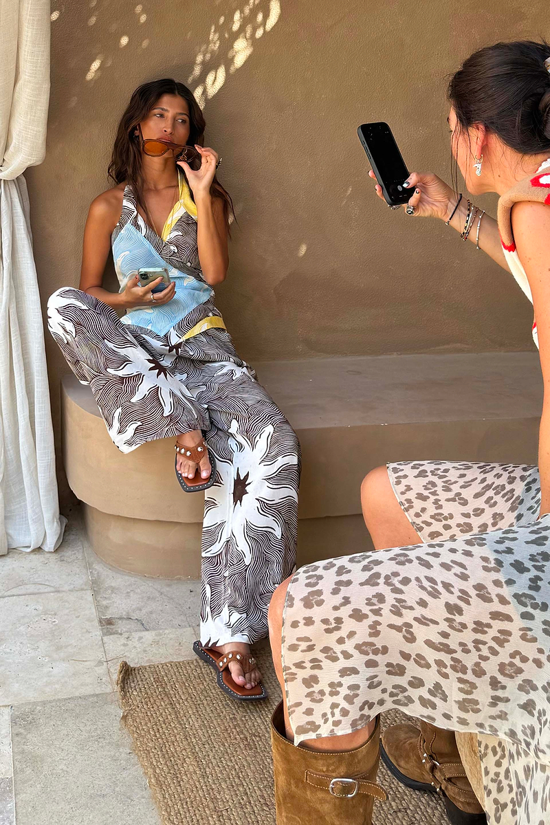 Chocolate Soleil Ellie Trousers and wrap top in a sun motif, styled as a wide-leg co-ord in a Mediterranean setting.