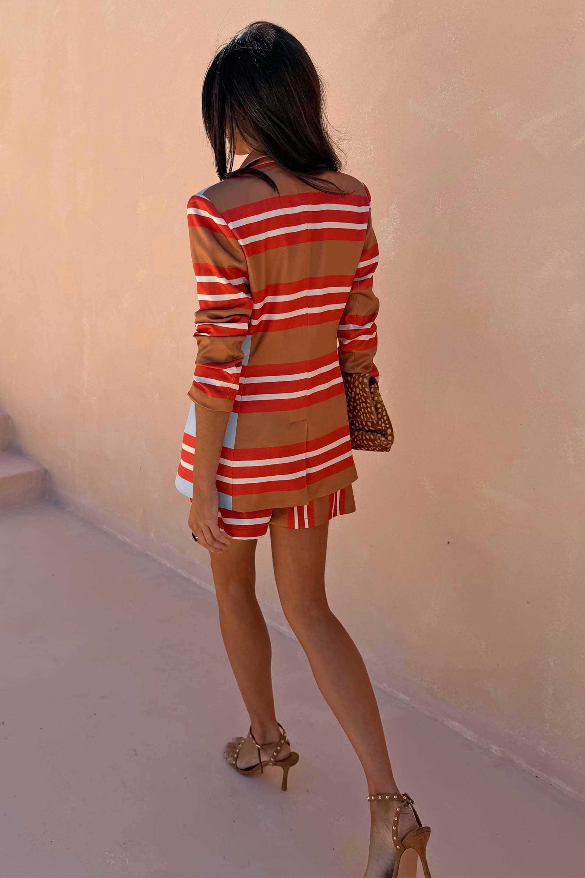 Multi Stripe Blazer in red and blue satin-esque fabric, longline fit, styled with matching shorts and leopard clutch.