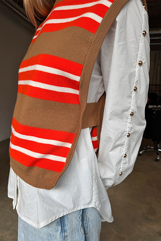 Multi Stripe Tank Top in tan and red knit, layered over a white shirt with gold button sleeve details.