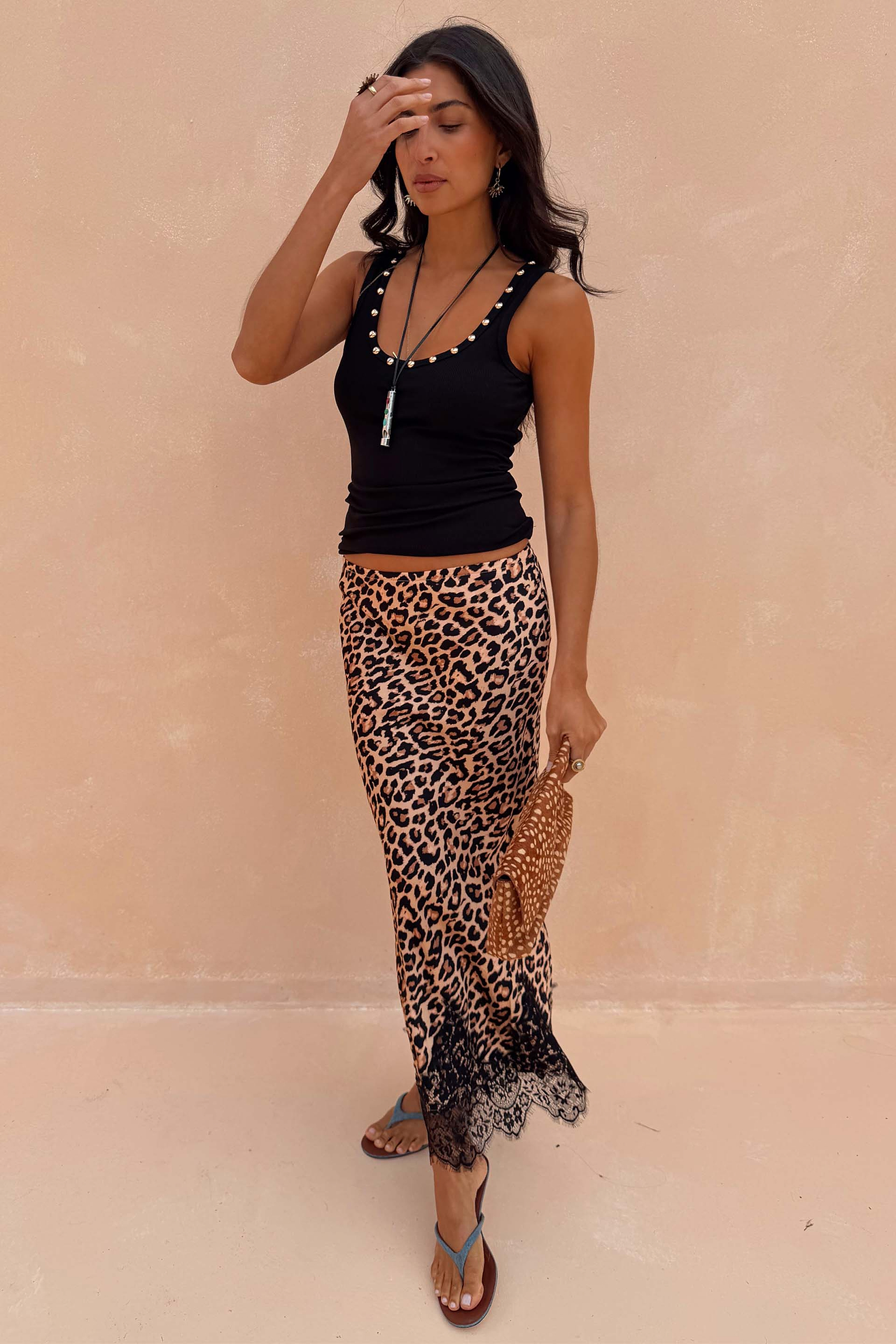 Black Studded Rib Vest featuring gold neckline detailing, styled with a leopard print lace-trimmed skirt.