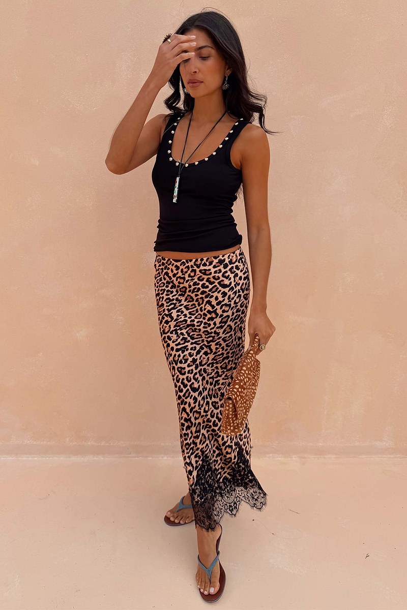 Black Studded Rib Vest featuring gold neckline detailing, styled with a leopard print lace-trimmed skirt.