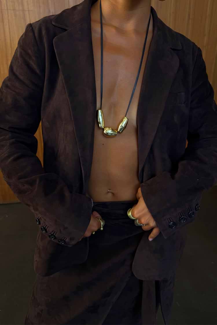 Chocolate Suede Jacket with notched lapels and buttoned cuffs, styled with gold jewellery for a premium London look.