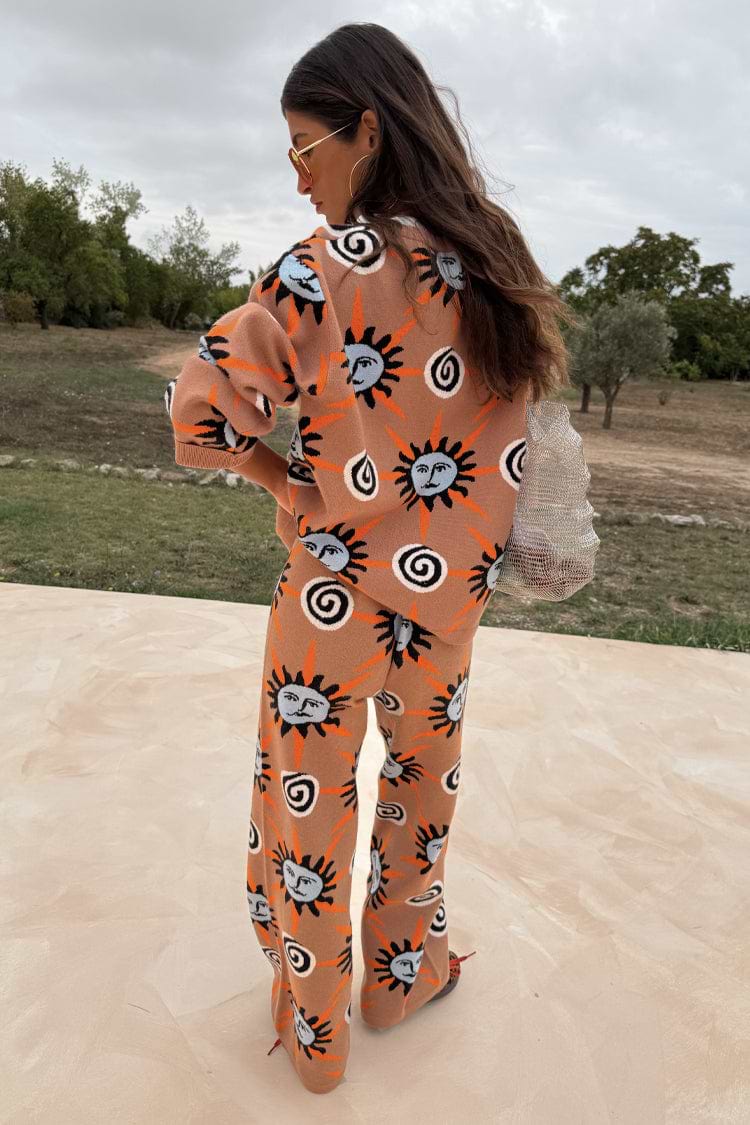Tan Sun Trousers and matching knit jumper featuring Mediterranean-inspired sun motifs, viewed from behind.
