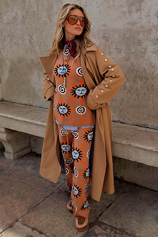 Tan Sun Copenhagen Jumper with hand-painted sun motifs, styled as a co-ord under a tan trench coat.