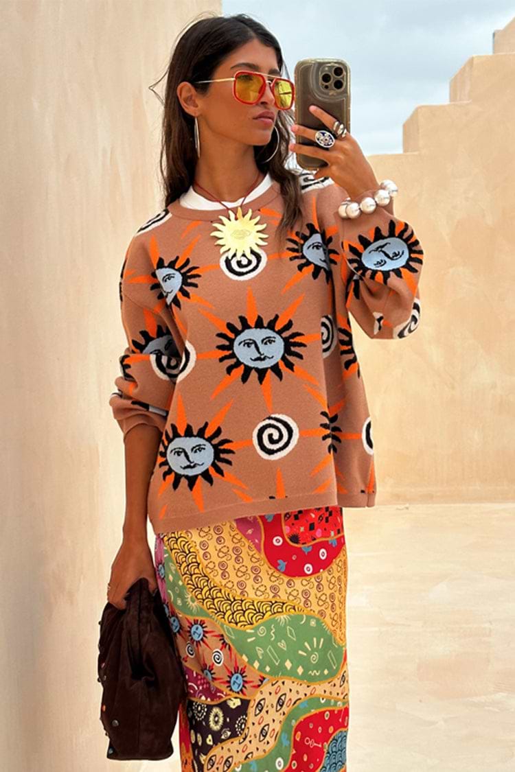 Tan Sun Copenhagen Jumper in a tan knit with hand-painted sun motifs, styled with a colourful patterned skirt.