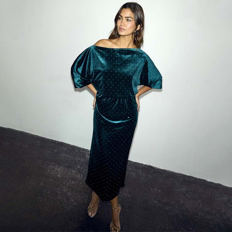 Emerald Velvet Tilly Dress Petite with a voluminous off-the-shoulder top and fitted skirt on a model.