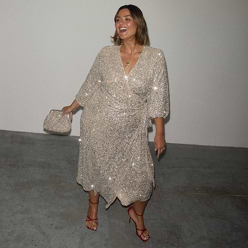 Silver Sequin Kira Wrap Dress with a multi-wear tie waist, red heels and a silver clutch bag.