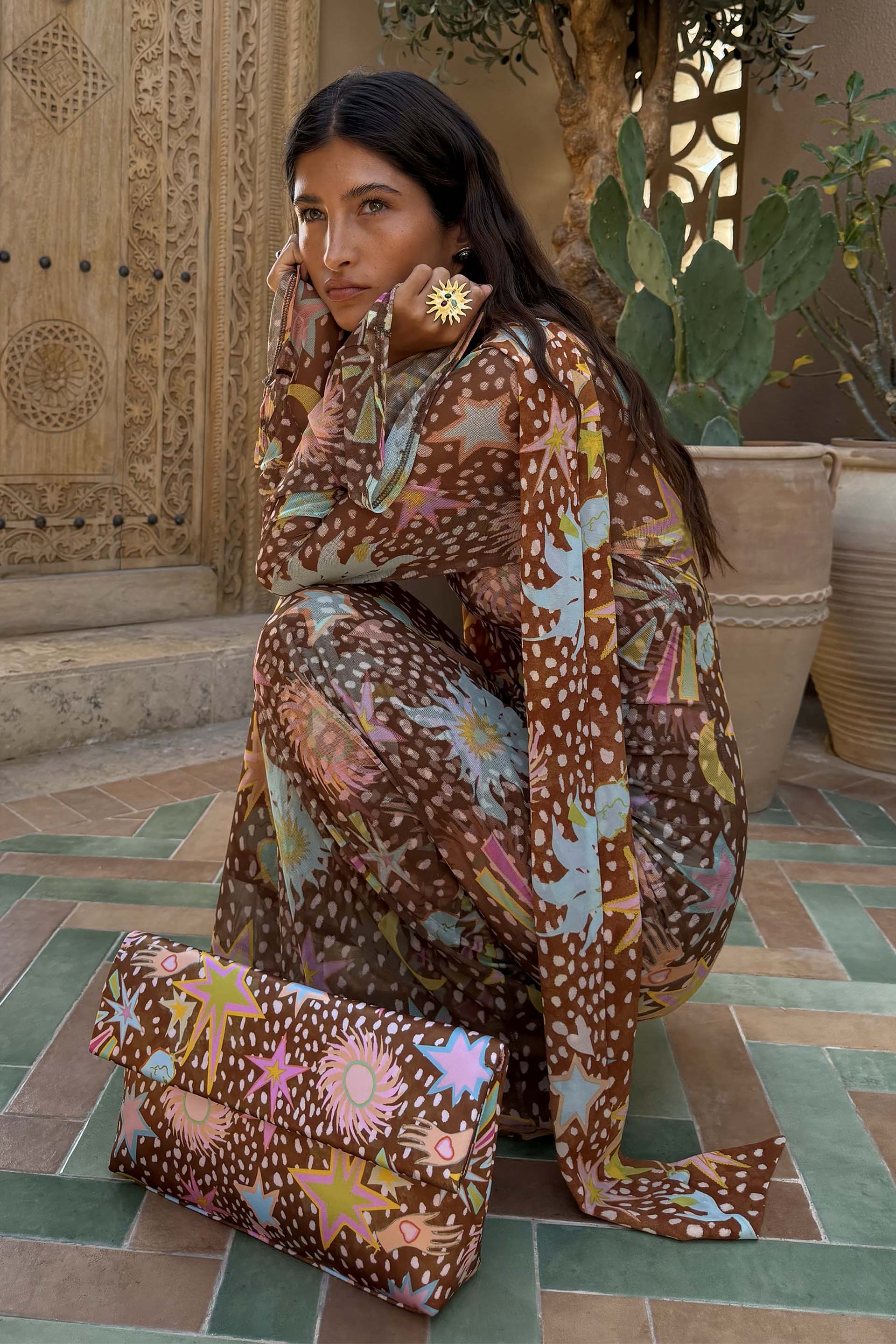 Brown Star Fawn Aria Mesh Dress featuring fawn spots and sun motifs, paired with a matching printed clutch bag.
