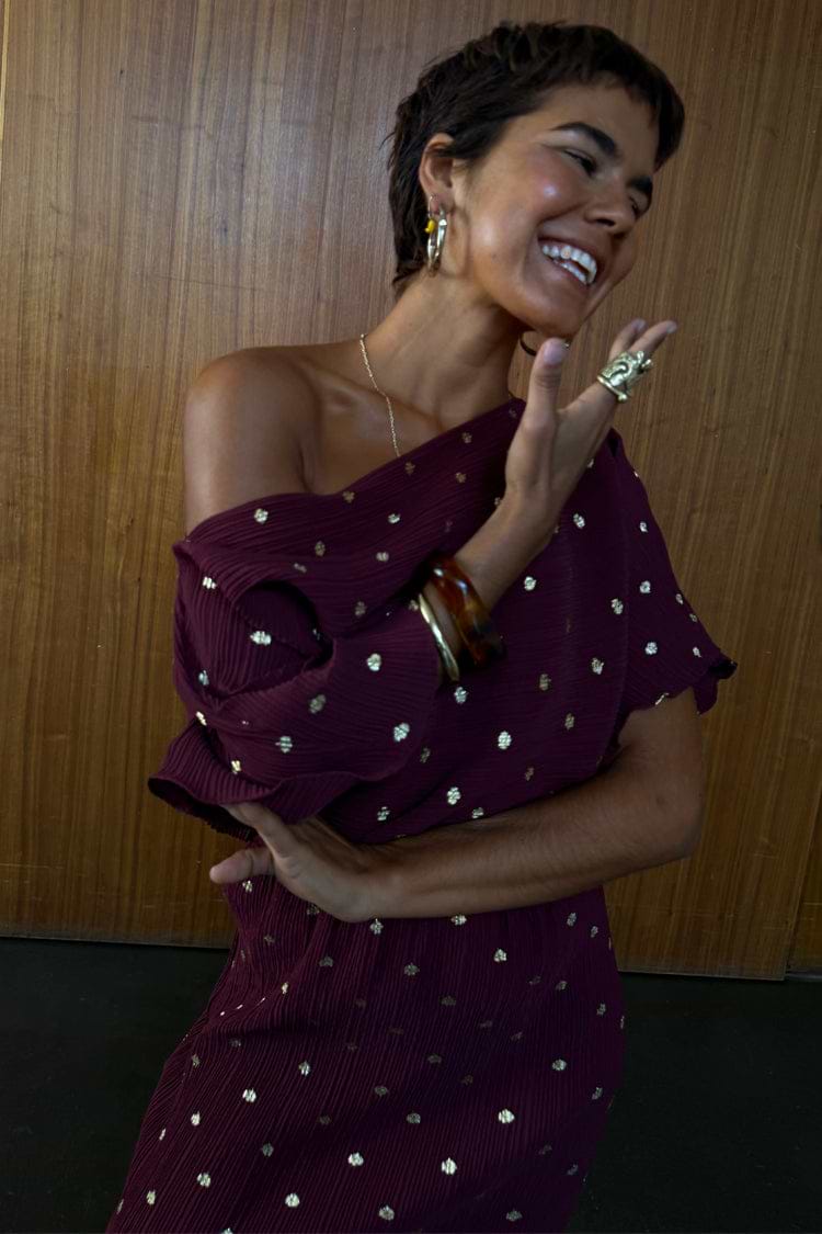 Burgundy Tilly Dress in gold-flecked plisse fabric, designed in London with an off-the-shoulder multi-wear neckline.