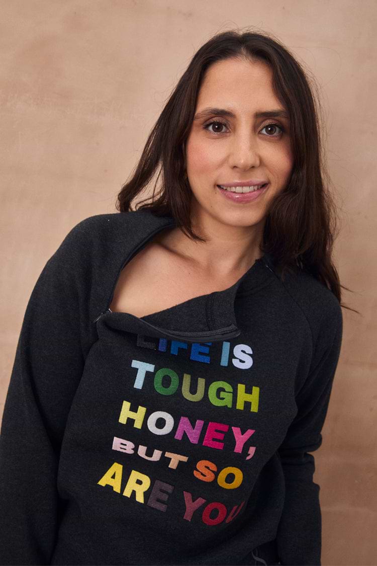 Charcoal sweatshirt featuring colourful "Life is tough honey" embroidery and a functional neckline zip.