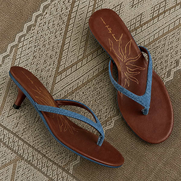 Denim Sandal Mules featuring slim blue straps, a low sculpted kitten heel, and brown cushioned soles with a sun motif.