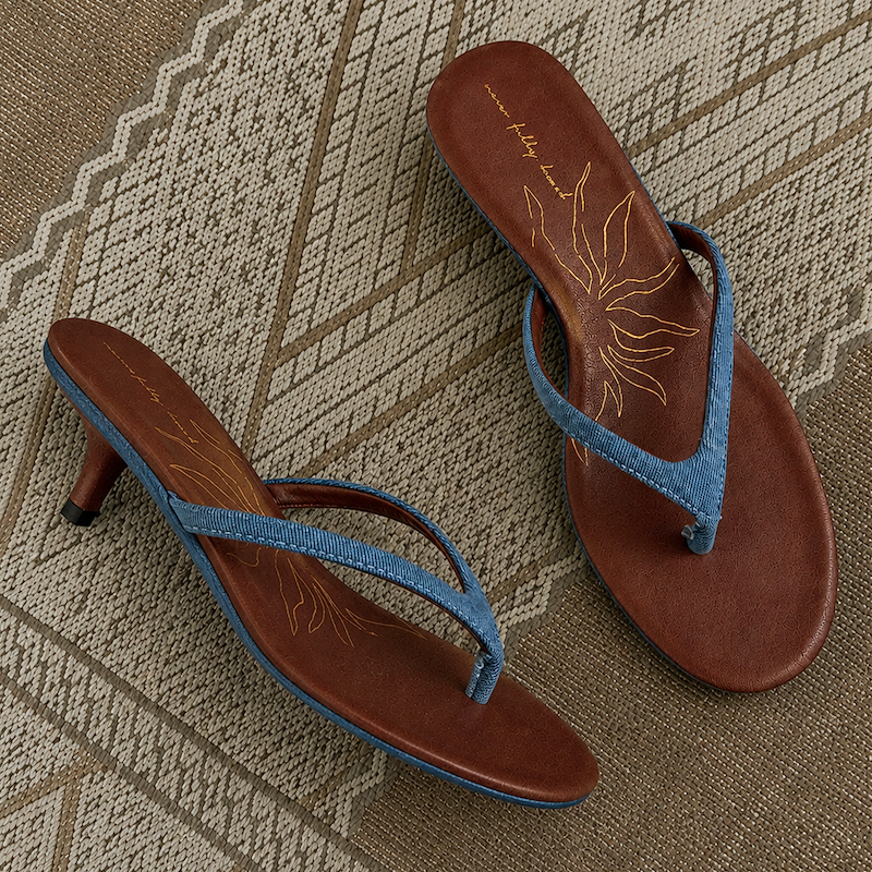 Denim Sandal Mules featuring slim blue straps, a low sculpted kitten heel, and brown cushioned soles with a sun motif.
