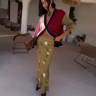 Olive Mystical Dorris Skirt with sun motifs on green viscose, paired with a colour-block cardigan and leopard clutch.