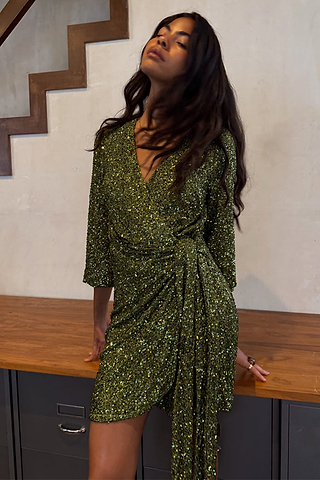 Olive Sequin Mini Vienna Dress in a multi-wear wrap style with long sleeves, worn by a model.