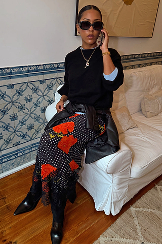 Black Poppy Midi Maeva Skirt with red poppy and polka dot print and lace trim, styled with a black jumper and leather jacket.