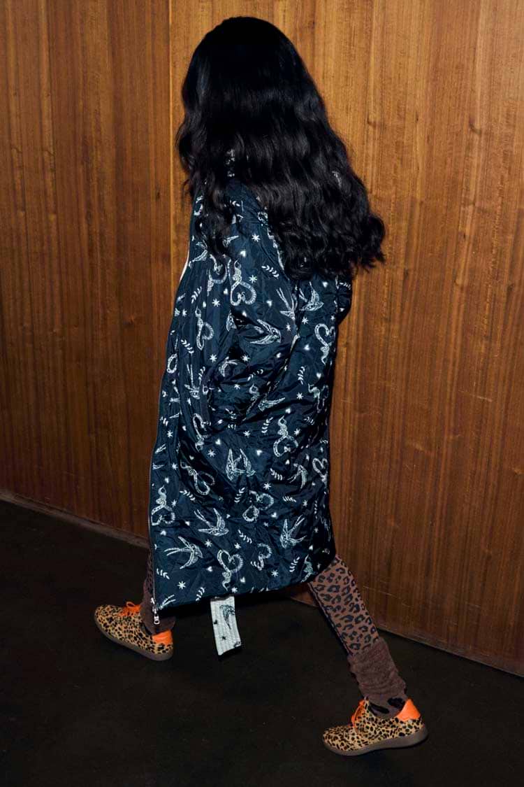 Mono Swallow Romance Reversible Coat with a black and white swallow print, shown on a model walking.