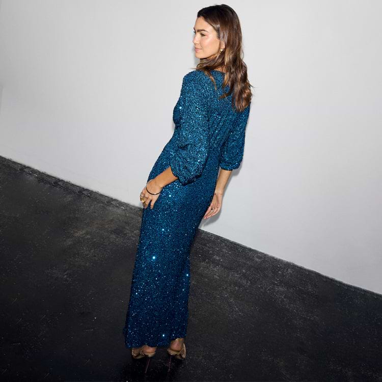 Teal Sequin Emma Dress with premium shimmering sequins and a draped silhouette, shown from a side-back view.