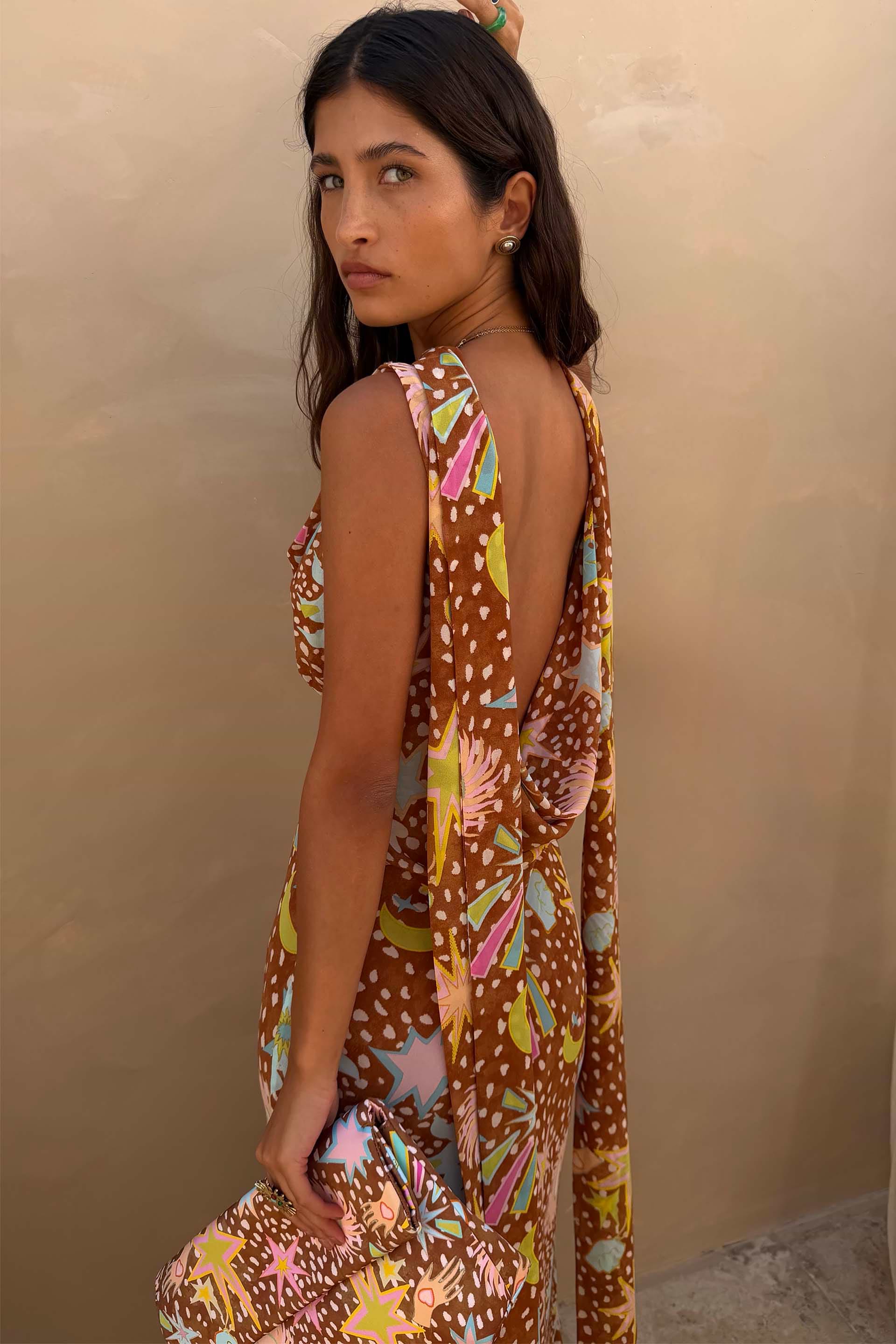 Star Fawn Sophie Dress in brown with a low back and detachable scarf detail, held with a matching clutch.