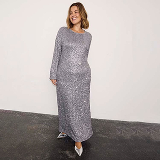 Gunmetal Sequin Soho Dress Petite with all-over sequins, long sleeves and a maxi length on a smiling model.