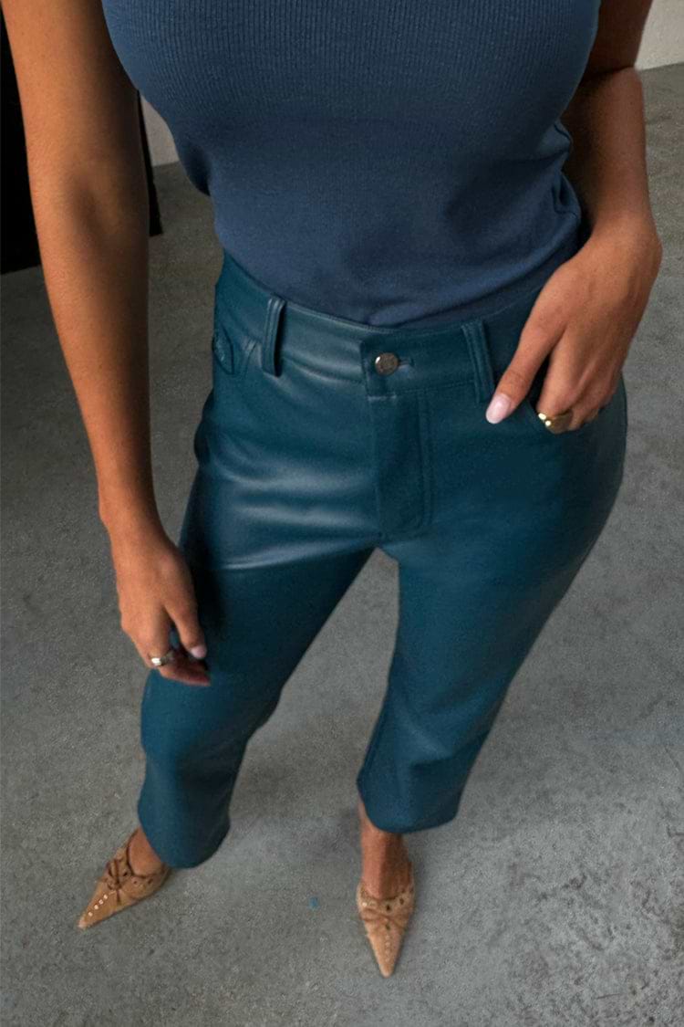 Teal Vegan Leather Trousers in a straight leg fit, styled with a blue ribbed tank top and pointed tan heels.