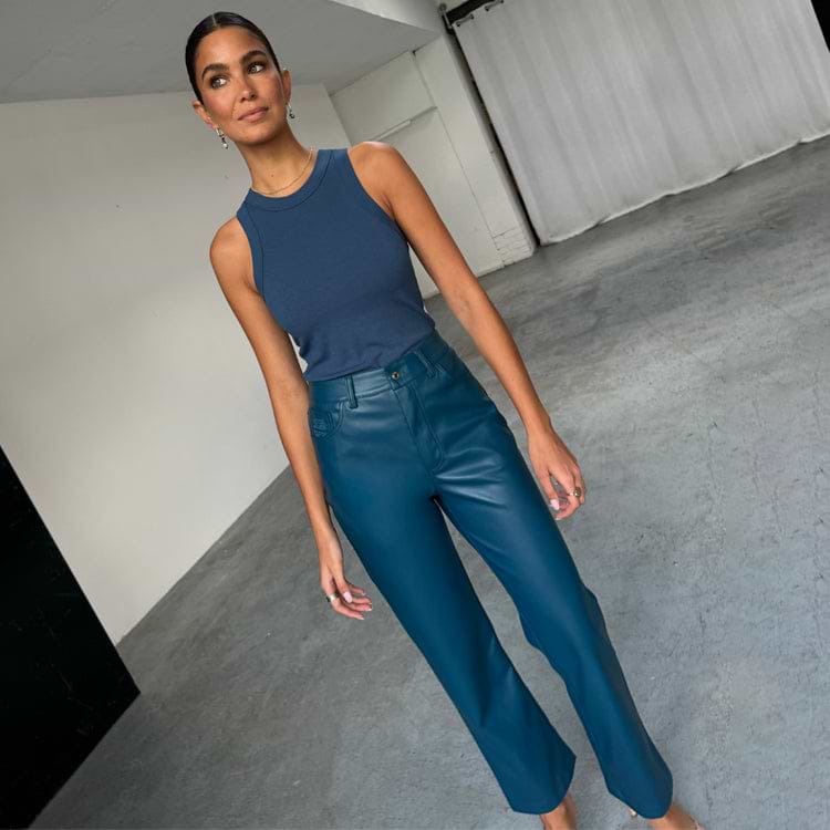 Model wearing Teal Vegan Leather Trousers in a straight leg fit, paired with a blue ribbed tank top.