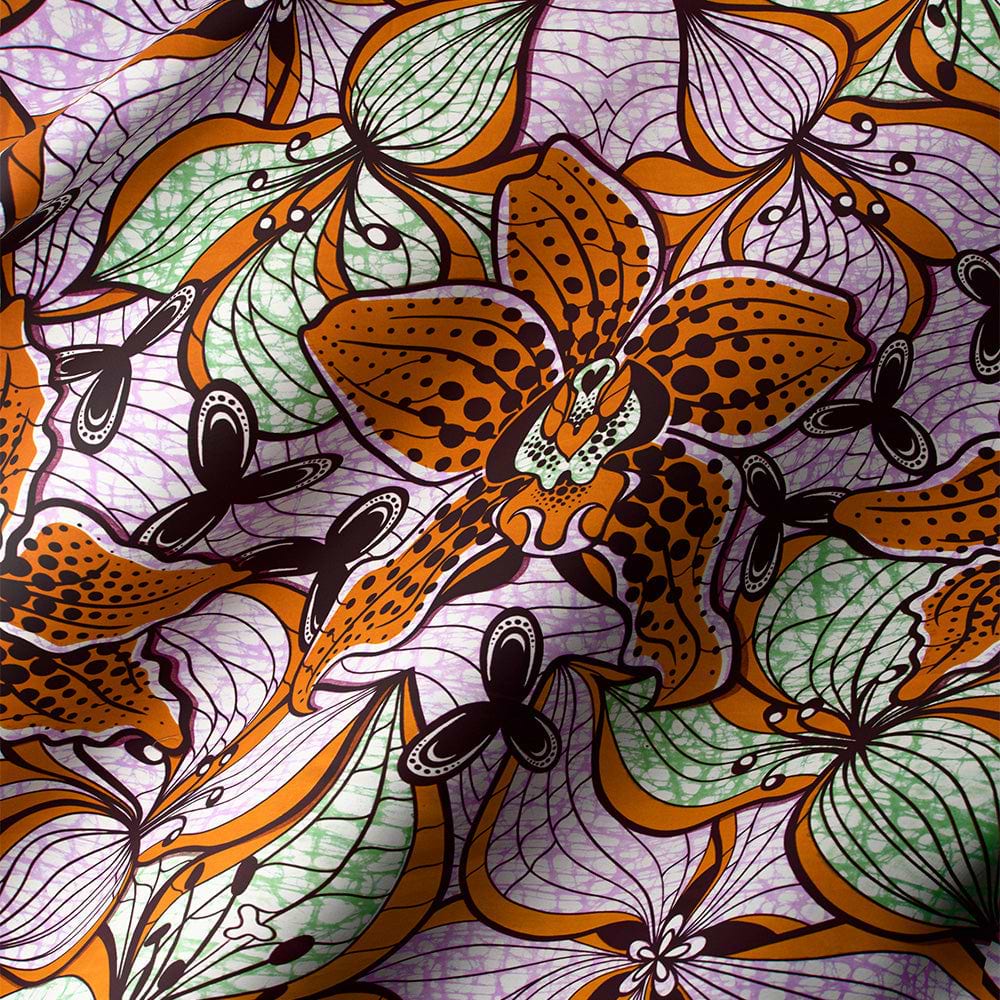 Wax print fabric featuring spiral patterns against a deep red background.