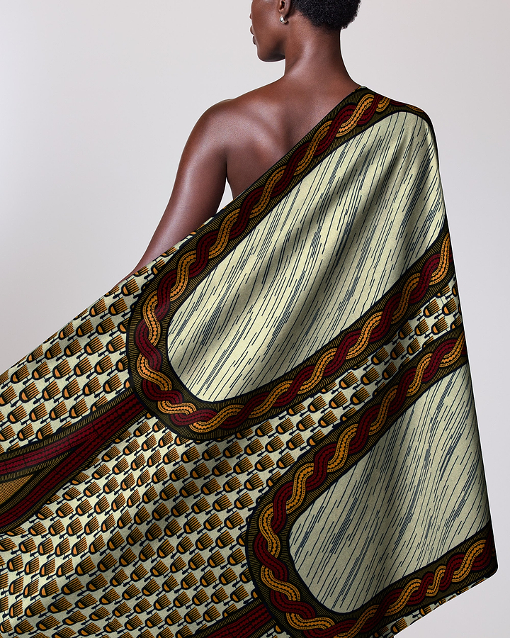 Woman wears vibrant one-shoulder wrap wax hollandais vl04295.084