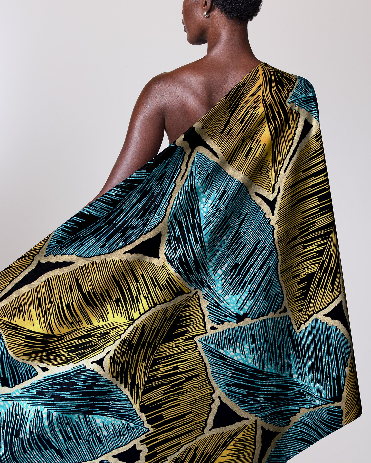 Woman wears vibrant one-shoulder wrap wax hollandais vl08946.010