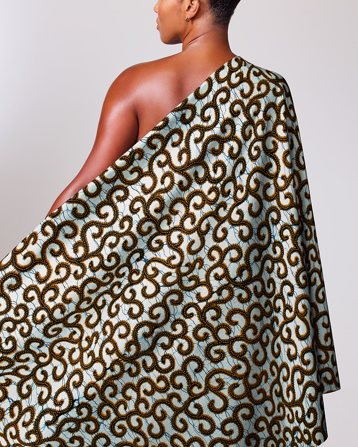 Woman wears one-shoulder wrap dress wax hollandais vl0h907.145