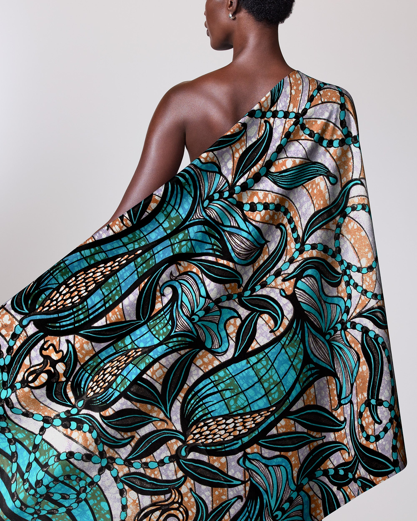 Woman wears vibrant one-shoulder wrap grand super-wax vls9099.004