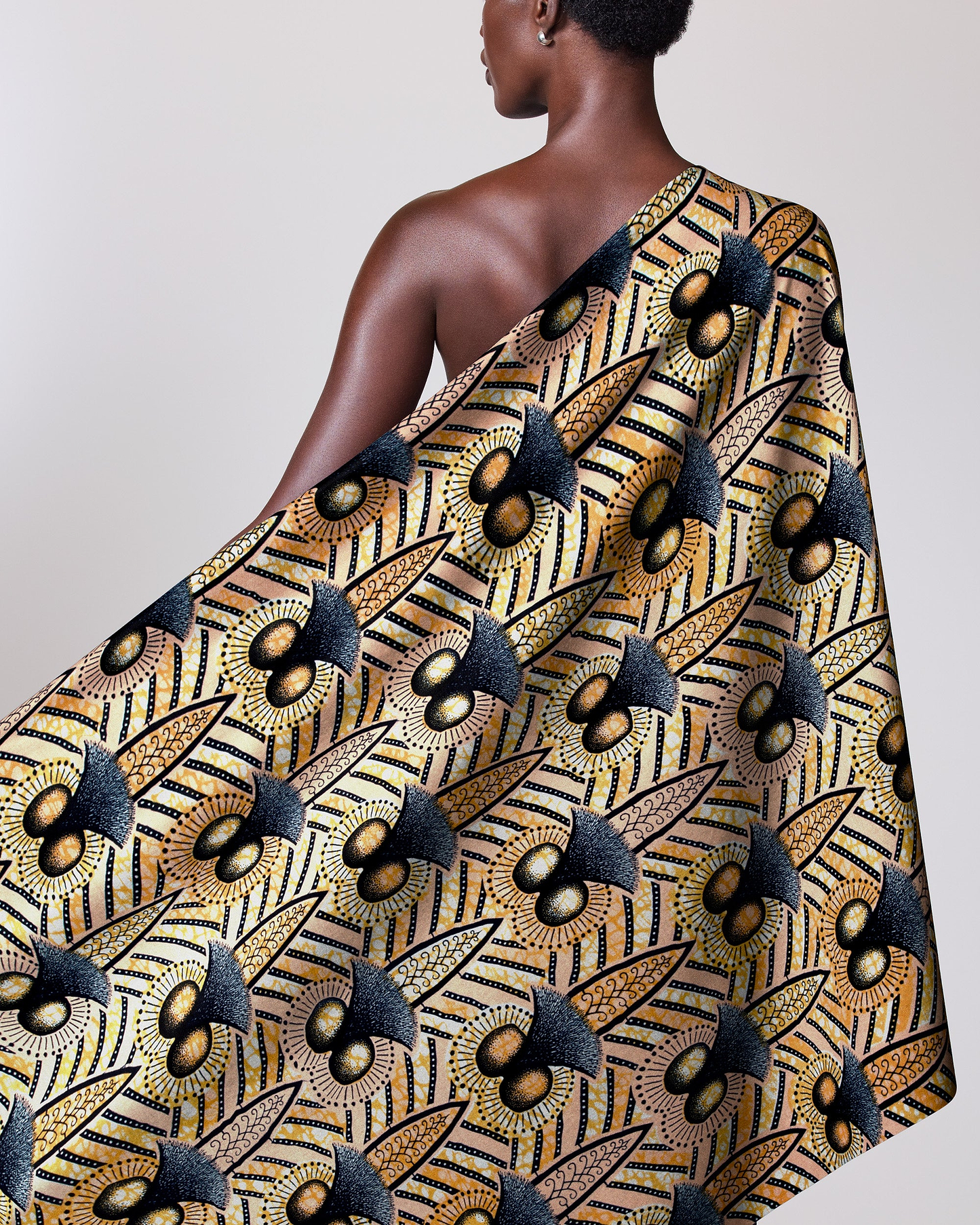 Woman wears vibrant one-shoulder wrap wax hollandais vlw9321.001